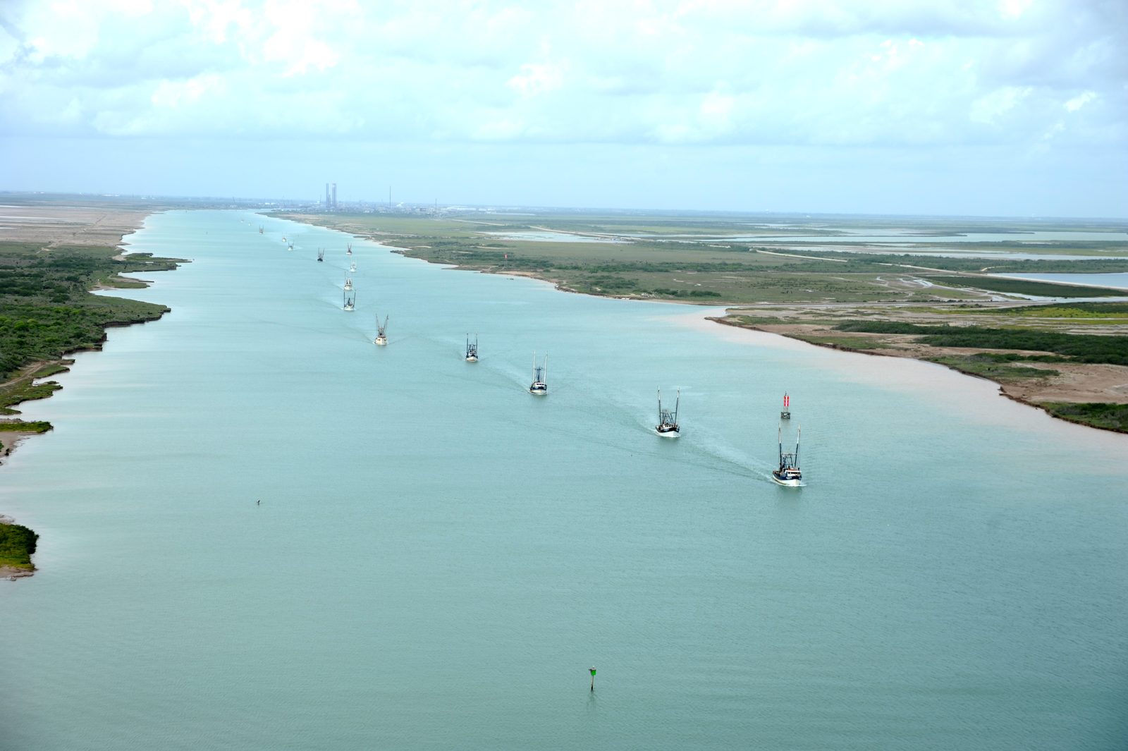 Shrimp boats heading down the Brownsville Ship Channel toward the Gulf, seen from the air